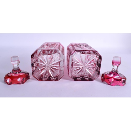 36 - A PAIR OF BOHEMIAN RUBY FLASH DECANTERS AND STOPPERS with star curt decoration. 25 cm x 8 cm.