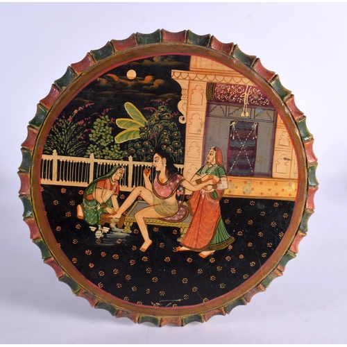 367 - AN UNUSUAL INDIAN PAINTED WOODEN TABLE depicting a female having her feet washed. 44 cm x 20 cm.