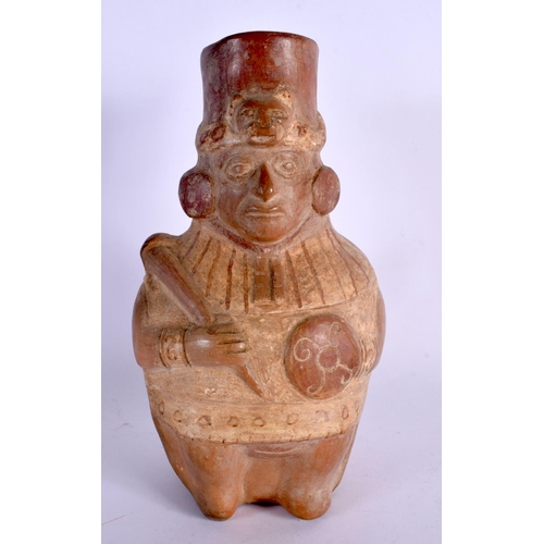402 - A SOUTH AMERICAN CARVED AND PAINTED TERRACOTTA FIGURE modelled holding a shield and weapon. 24 cm x ... 