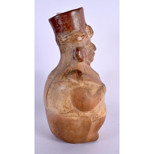 402 - A SOUTH AMERICAN CARVED AND PAINTED TERRACOTTA FIGURE modelled holding a shield and weapon. 24 cm x ... 