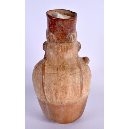 402 - A SOUTH AMERICAN CARVED AND PAINTED TERRACOTTA FIGURE modelled holding a shield and weapon. 24 cm x ... 