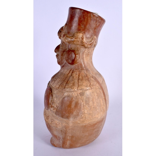 402 - A SOUTH AMERICAN CARVED AND PAINTED TERRACOTTA FIGURE modelled holding a shield and weapon. 24 cm x ... 