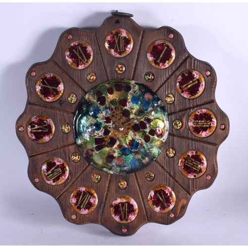 408 - A VERY RARE EARLY 20TH CENTURY CARVED WOOD AND ENAMEL MANTEL CLOCK set with numerous roundels. 34 cm... 