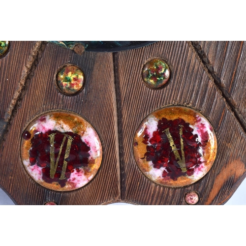 408 - A VERY RARE EARLY 20TH CENTURY CARVED WOOD AND ENAMEL MANTEL CLOCK set with numerous roundels. 34 cm... 