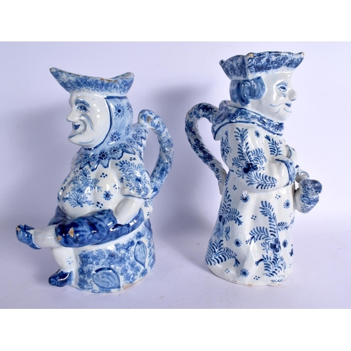 42 - A LARGE PAIR OF ANTIQUE DELFT BLUE AND WHITE CHARACTER TOBY JUGS painted with motifs. 27 cm x 14 cm.