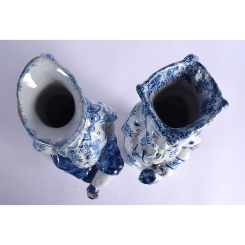 42 - A LARGE PAIR OF ANTIQUE DELFT BLUE AND WHITE CHARACTER TOBY JUGS painted with motifs. 27 cm x 14 cm.