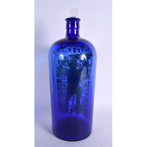 5 - A LOVELY SEQUAHS OIL ADVERTISING BLUE GLASS BOTTLE modelled with a wrestler upon a skull. 37 cm high... 