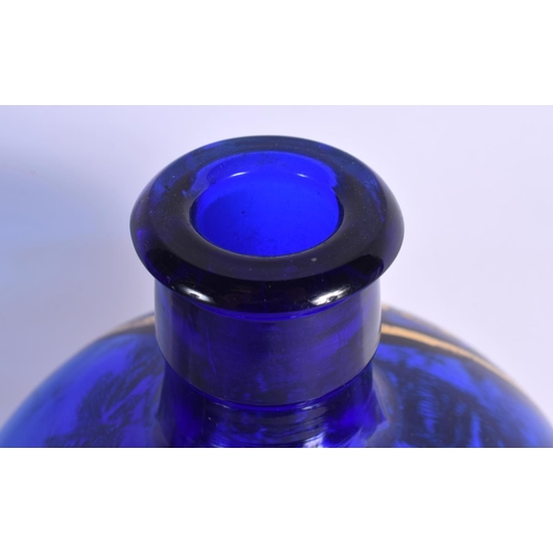 5 - A LOVELY SEQUAHS OIL ADVERTISING BLUE GLASS BOTTLE modelled with a wrestler upon a skull. 37 cm high... 