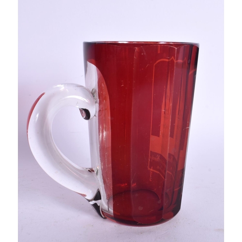 58 - AN ANTIQUE GERMAN RUBY BOHEMIAN GLASS MUG engraved with buildings. 11.5 cm high.