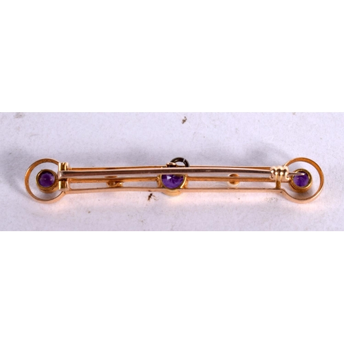 1245 - A 15CT GOLD BAR BROOCH INSET WITH PEARLS AND PURPLE GEMS.  5cm long, weight 3.7g