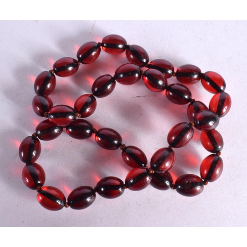 1256 - A STRING OF CHERRY COLOURED BEADS.  62cm long, weight 65g