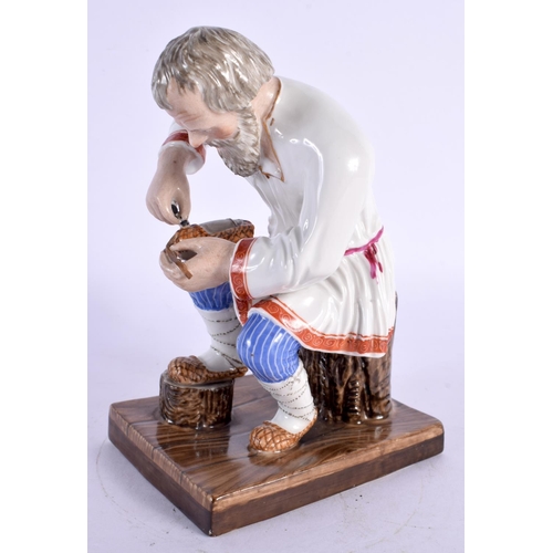 278 - A RUSSIAN PORCELAIN FIGURE OF A SEATED MALE modelled repairing shoes. 15 cm x 8 cm.