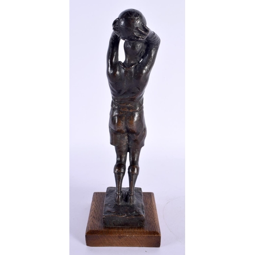 291C - A RARE 1940S BRONZE FIGURE OF A FOOTBALL PLAYER modelled upon an oak plinth. 24 cm high.