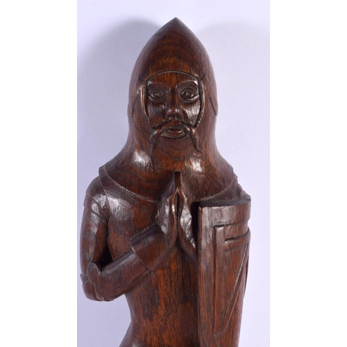 293D - AN ARTS AND CRAFTS CARVED WOOD FIGURE OF A SOLDIER modelled standing upon a lion. 45 cm high.