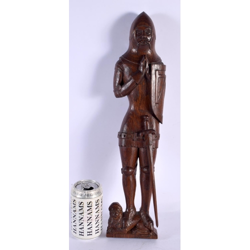 293D - AN ARTS AND CRAFTS CARVED WOOD FIGURE OF A SOLDIER modelled standing upon a lion. 45 cm high.