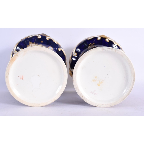 294D - A PAIR OF MID 19TH CENTURY ENGLISH PORCELAIN FLUTED VASES painted with flowers upon a blue ground. 1... 