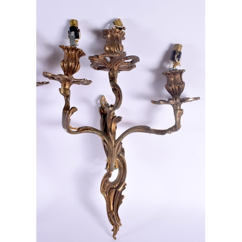 323 - A PAIR OF VINTAGE COUNTRY HOUSE GILT METAL TRIPLE BRANCH CANDLE WALL SCONCES. 46 cm x 24 cm.