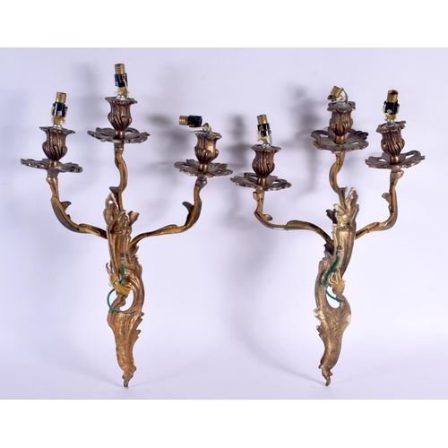 323 - A PAIR OF VINTAGE COUNTRY HOUSE GILT METAL TRIPLE BRANCH CANDLE WALL SCONCES. 46 cm x 24 cm.