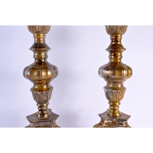 324 - A LARGE PAIR OF ANTIQUE CONTINENTAL BRASS CANDLESTICKS. 58 cm high.