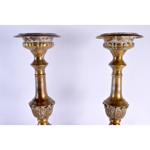 324 - A LARGE PAIR OF ANTIQUE CONTINENTAL BRASS CANDLESTICKS. 58 cm high.