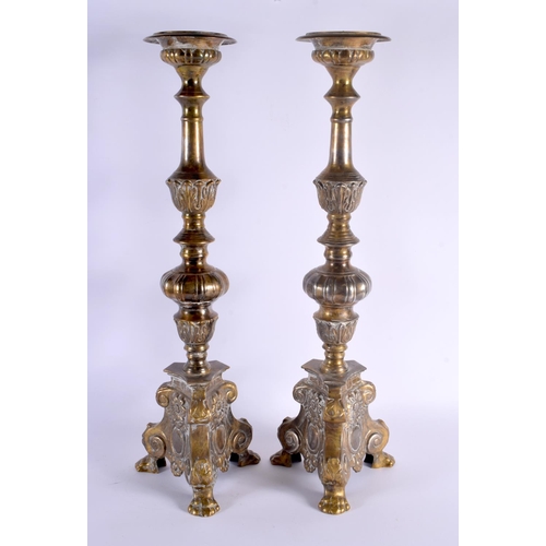 324 - A LARGE PAIR OF ANTIQUE CONTINENTAL BRASS CANDLESTICKS. 58 cm high.