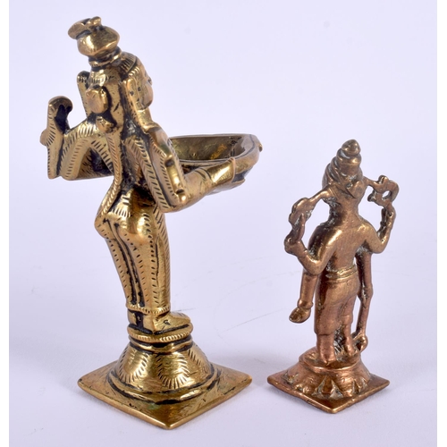 334 - AN 18TH CENTURY INDIAN BRONZE FIGURE OF A BUDDHISTIC DEITY modelled holding an oil burner, together ... 