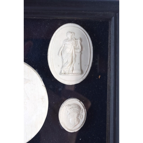 391 - A FRAMED SET OF EARLY 20TH CENTURY PLASTER INTAGLIO CAMEOS. 28 cm x 20 cm.