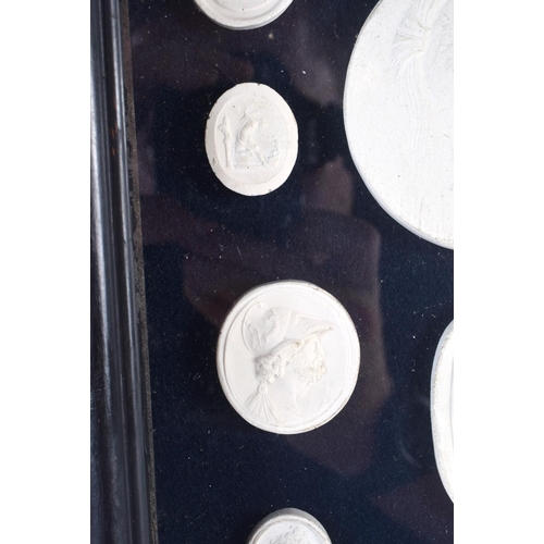 391 - A FRAMED SET OF EARLY 20TH CENTURY PLASTER INTAGLIO CAMEOS. 28 cm x 20 cm.