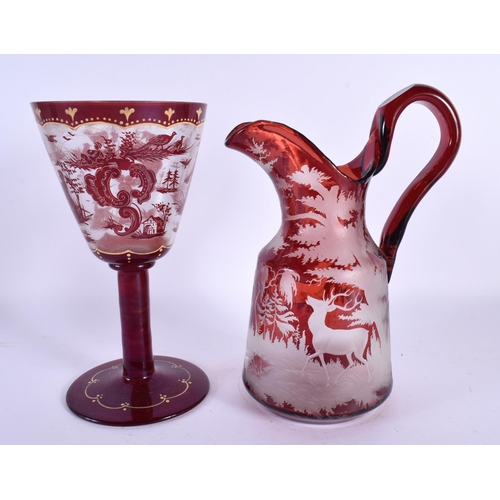 45 - A LARGE BOHEMIAN RUBY GLASS JUG together with a similar chalice Largest 25 cm high. (2)