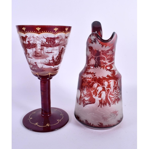 45 - A LARGE BOHEMIAN RUBY GLASS JUG together with a similar chalice Largest 25 cm high. (2)