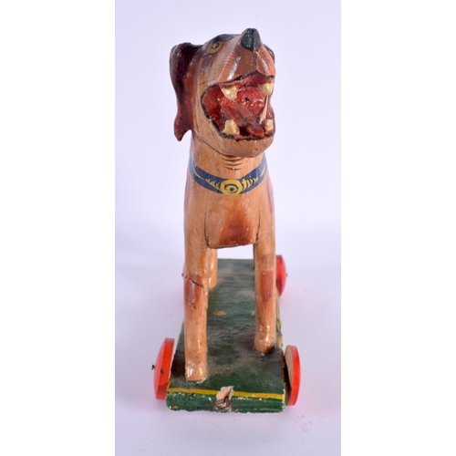 491 - A VINTAGE FOLK ART CARVED WOOD PULL ALONG DOG. 24 cm x 16 cm.