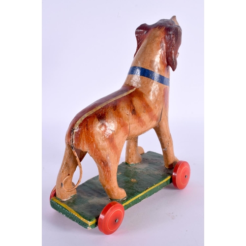 491 - A VINTAGE FOLK ART CARVED WOOD PULL ALONG DOG. 24 cm x 16 cm.