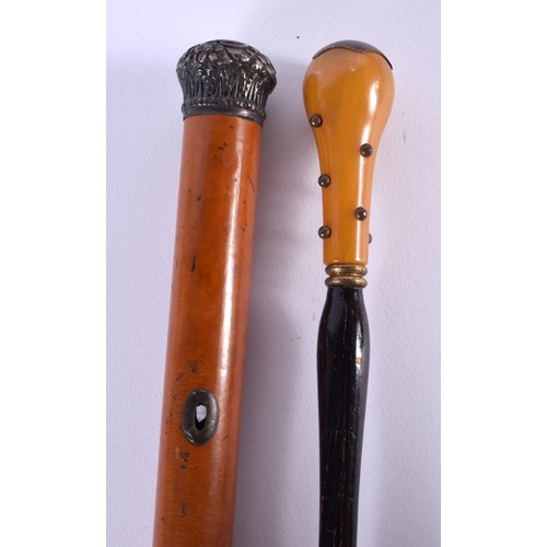 721A - AN ANTIQUE AMBER HANDLED PARASOL and a silver mounted cane. Largest 88 cm long. (2)