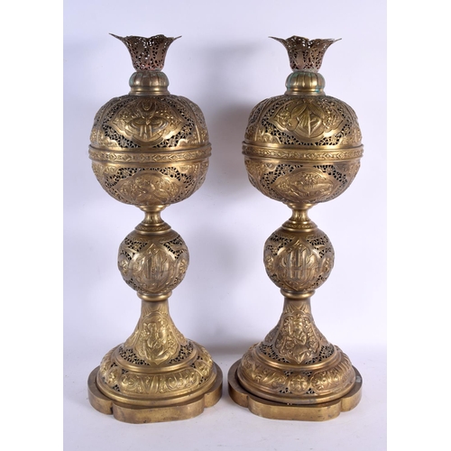 722 - A GOOD LARGE PAIR OF 19TH CENTURY MIDDLE EASTERN BRASS AND BRONZE LAMPS decorated with animals and k... 