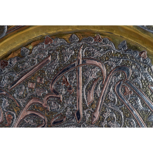 729 - A LARGE 19TH CENTURY MIDDLE EASTERN SILVER INLAID CIRCULAR PLATE decorated with a floral motif encas... 