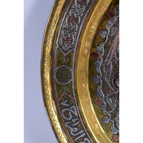 729 - A LARGE 19TH CENTURY MIDDLE EASTERN SILVER INLAID CIRCULAR PLATE decorated with a floral motif encas... 