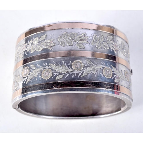 1038 - A VINTAGE SILVER TWO TONE BANGLE. 50 grams. 5.75 cm wide.