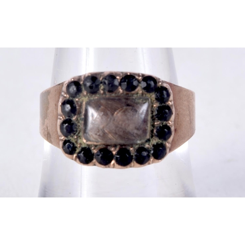 1042 - AN ANTIQUE YELLOW METAL GARNET AND HAIR MOURNING RING. N. 3.2 grams.