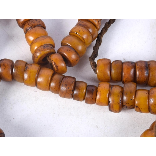 1058 - FOUR MIDDLE EASTERN AMBER TYPE PRAYER BEAD NECKLACES. 626 grams. Longest 86 cm. (4)