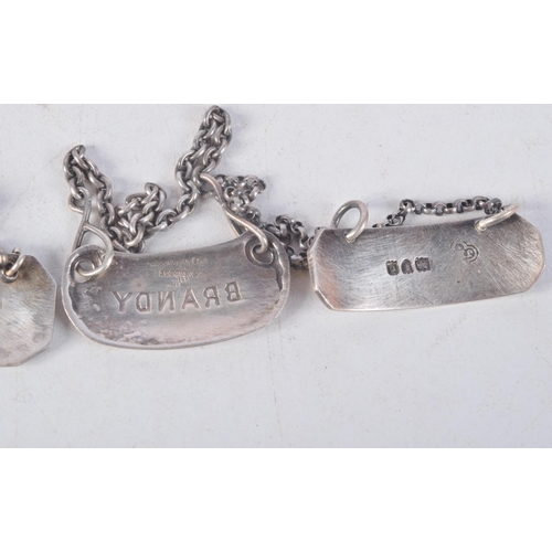 1153 - FOUR SILVER WINE LABELS. 16.5 grams. London 1899, 1900 & Tiffany. Largest 3 cm x 1 cm. (4)