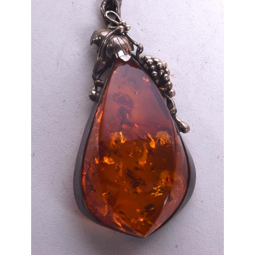 1260 - A SILVER BROOCH and an amber necklace. Necklace 70 cm long, pendant 7.75 cm x 3 cm. (2)