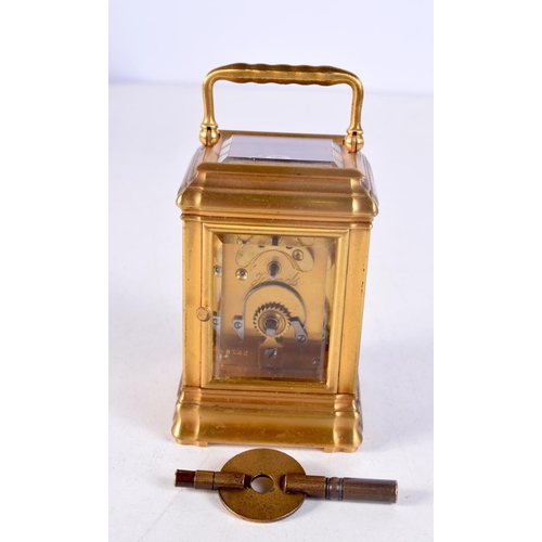 1483 - A MINIATURE BRASS CARRIAGE CLOCK. 9 cm high inc handle.