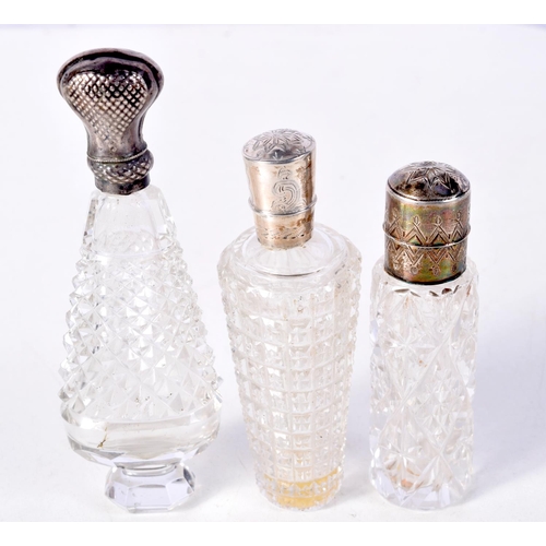 811 - THREE SILVER MOUNTED SCENT BOTTLES.  Largest 10.7cm x 3.6cm x 2.3cm (3)