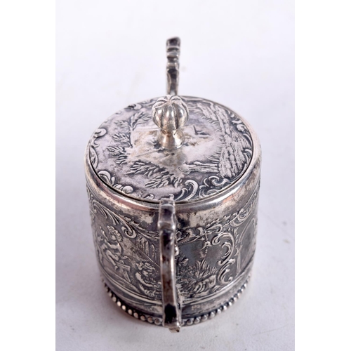 817 - A CONTINENTAL SILVER LIDDED POT DECORATED IN RELIEF WITH CHERUBS IN CLASSICAL SETTINGS.  4.7cm x 7.7... 