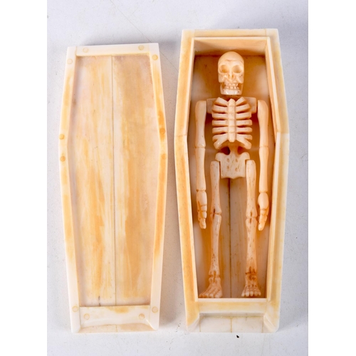 829 - A CARVED BONE COFFIN COMPLETE WITH A SKINNY OCCUPANT.  11.5cm x 2.8cm x 4.3cm