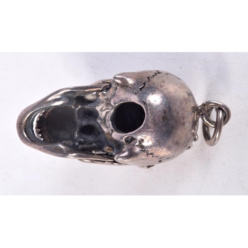 835 - A WHITE METAL SKULL PENDANT WITH GEM SET EYES AND AN ARTICULATED JAW.  3cm x 2.8cm x 2cm