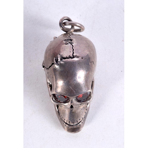 835 - A WHITE METAL SKULL PENDANT WITH GEM SET EYES AND AN ARTICULATED JAW.  3cm x 2.8cm x 2cm