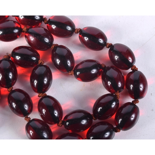 870 - A CHERRY AMBER COLOURED BEAD NECKLACE.  88cm long