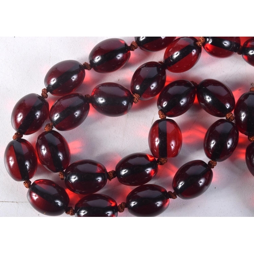 870 - A CHERRY AMBER COLOURED BEAD NECKLACE.  88cm long