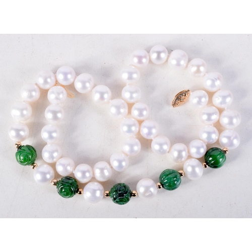 880 - A CARVED JADE AND PEARL NECKLACE WITH A 14CT GOLD CLASP.  Stamped 14K, Length 45cm, Pearl size 9.3mm